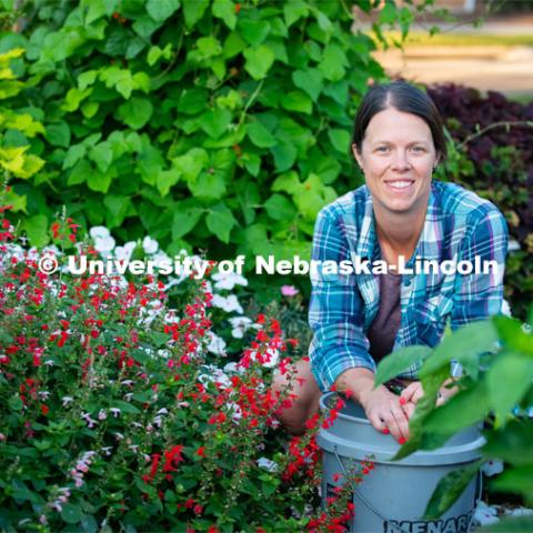 Ann Powers Research Technician, Agronomy and Horticulture, works in the Backyard Farmer Gardens. Today she is using a technique called deadheading to stimulate growth of new blossoms. August 6, 2019. Photo by Gregory Nathan / University Communication.